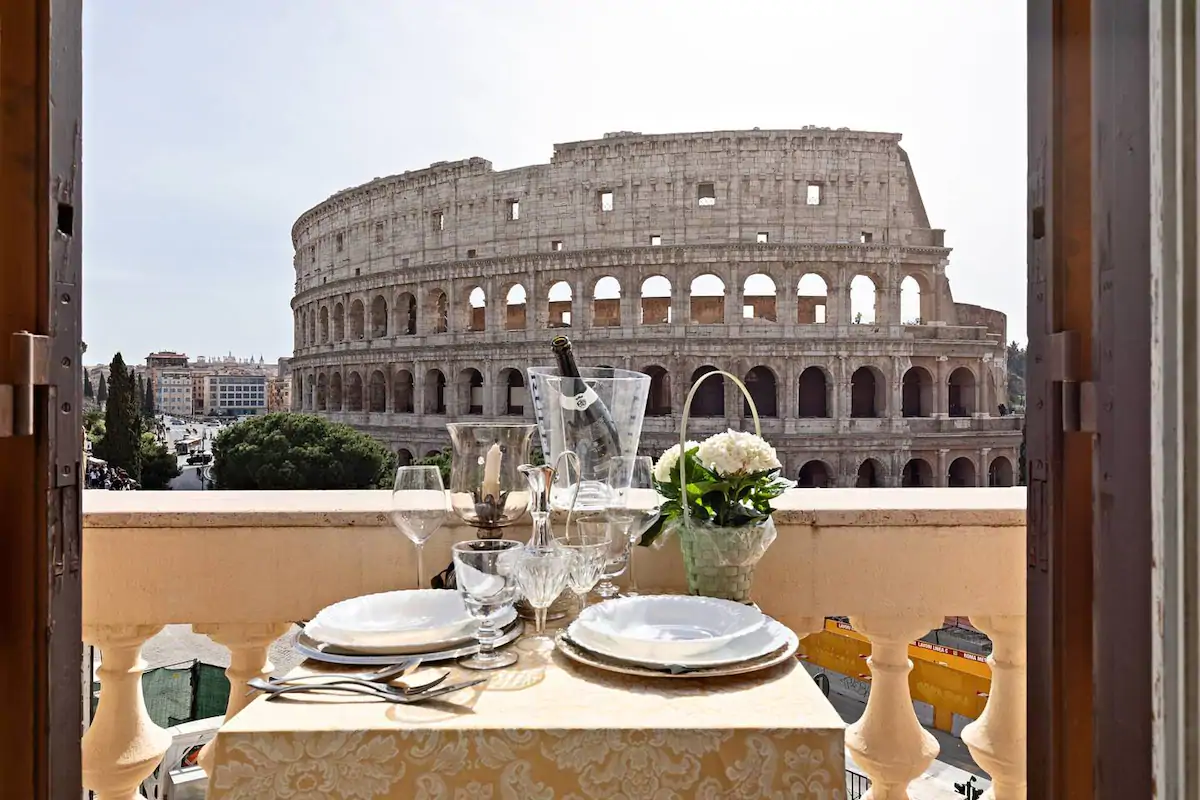 A table is made with a vase of flowers overlooking the Colosseum.