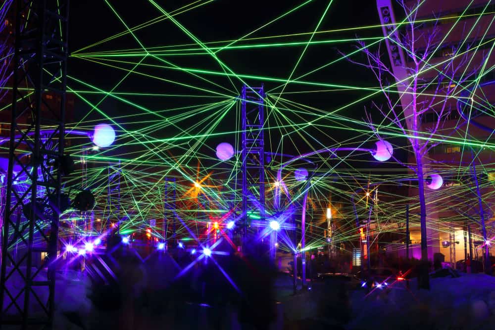 People move around outside at night surrounded by neon lights.