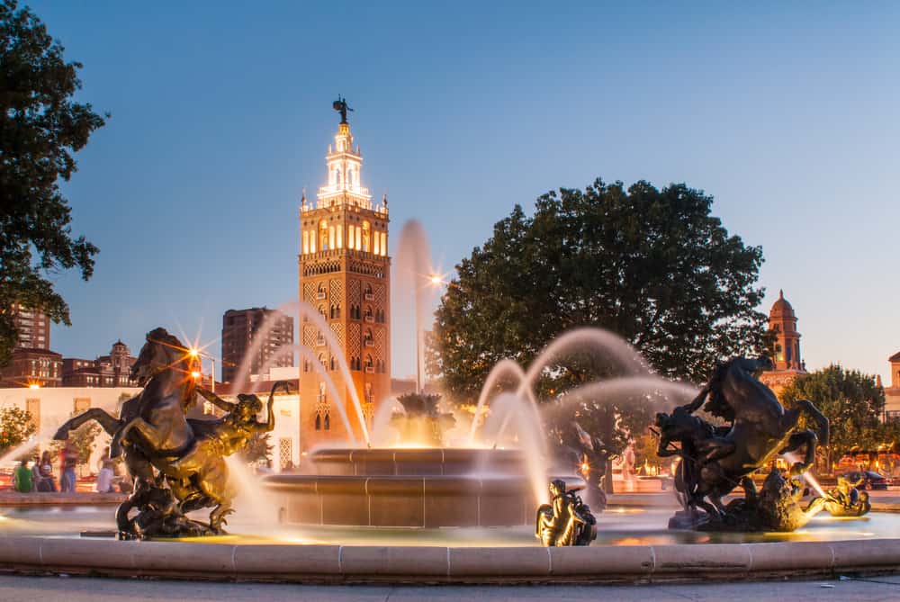 A fountain blasts water from it, surrounded by sculptures.