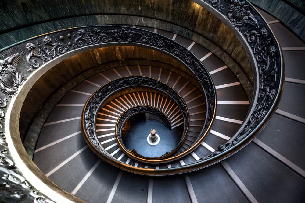 A dark spiral staircase leads to the bottom floor.