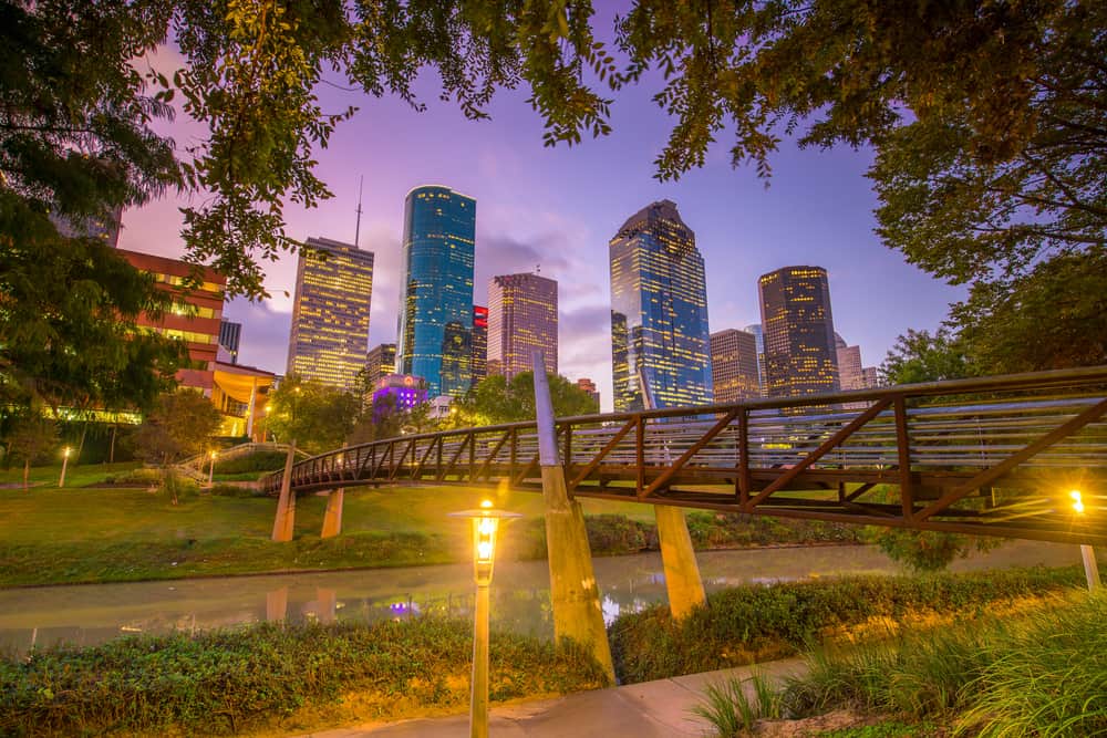 A city skyline at night under a purple sky.