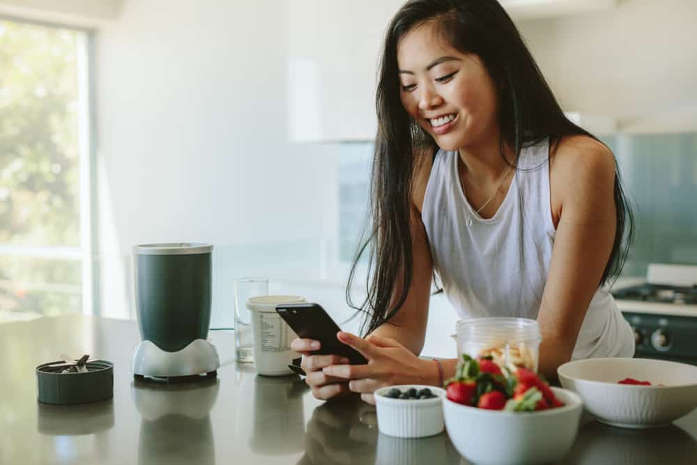 woman smiling in kitchen reading sweet good morning messages for her