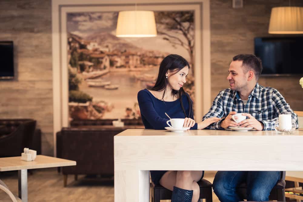 Couple in coffee shop asking each other deep Would You rather questions