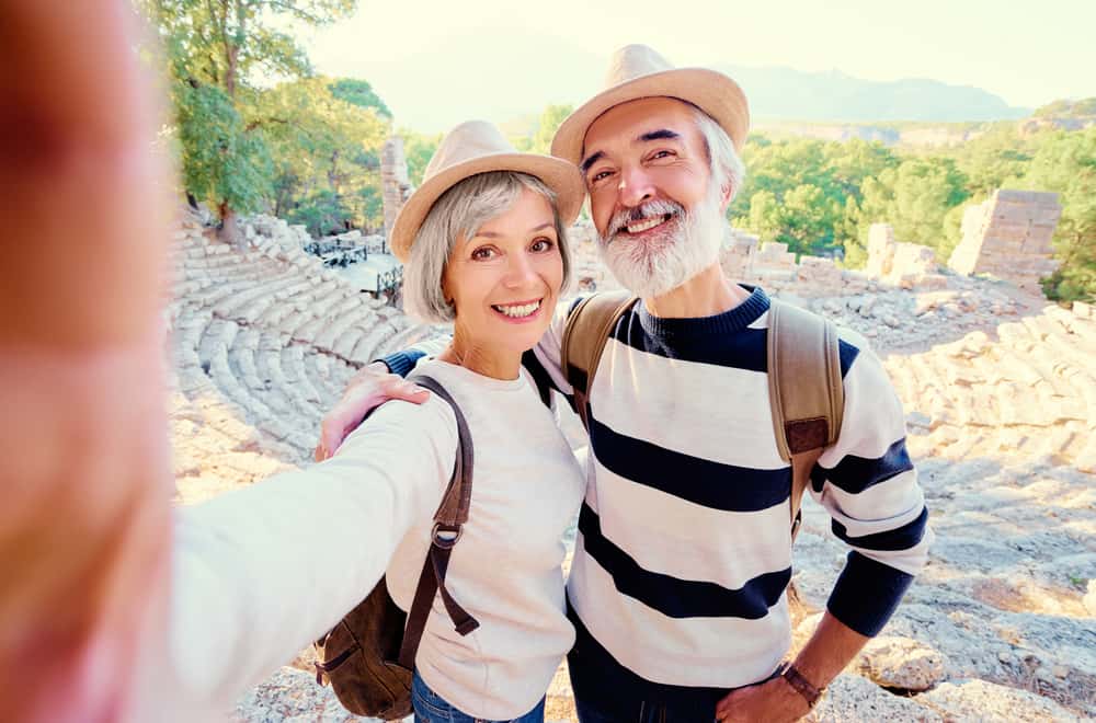 A mature couple takes a selfie at a historic landmark.