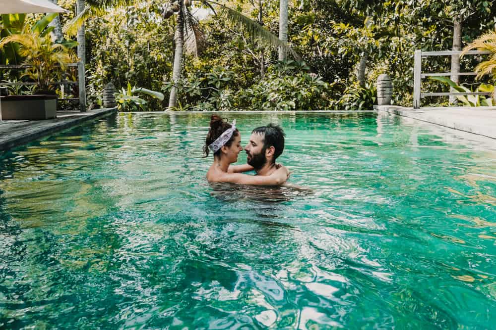 Couple embracing in infinity pool in a jungle resort in Bali