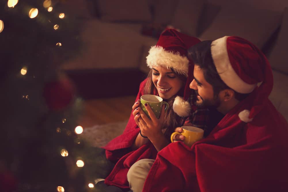 A couple snuggles together without sharing romantic Christmas messages for her