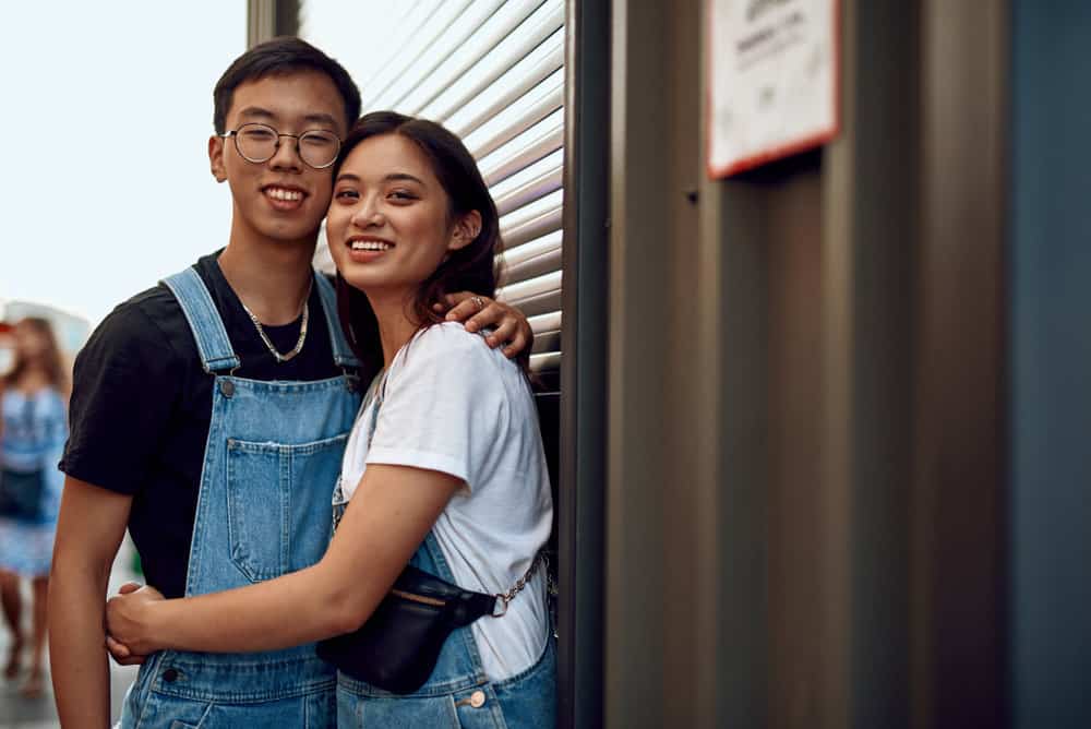A couple embraces next to a warehouse as they practice ways to stay true to themselves in a relationship