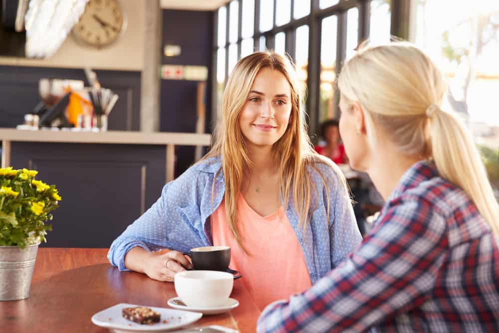 A couple is enjoying coffee and talking while at a cafe.