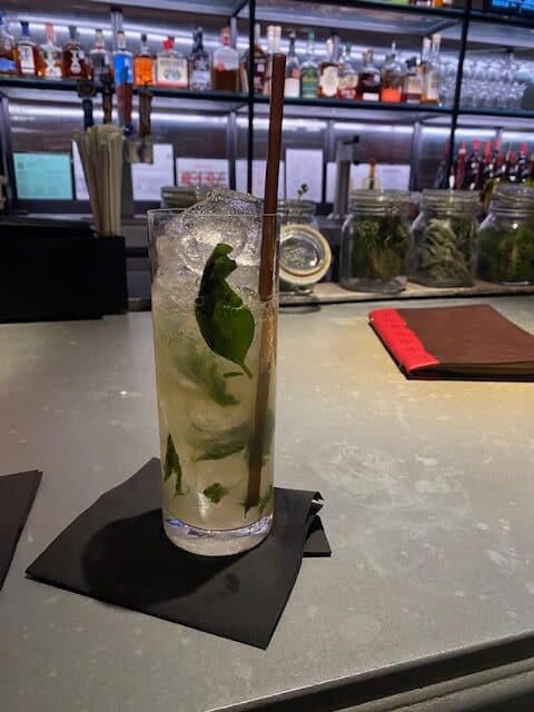 Cocktail glasses and adult beverages with fresh basil at one of the most popular San Antonio Riverwalk hotels