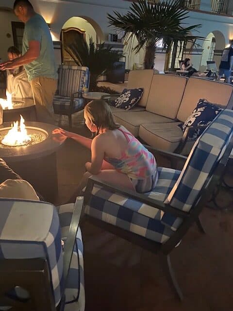 Uma criança se aquece perto de uma fogueira no pátio de um dos hotéis mais populares de San Antonio