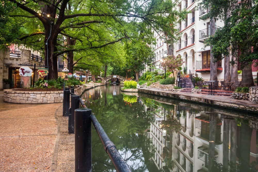  Der San Antonio River Walk mit Steinstegen und historischen Hotels entlang des Flusses